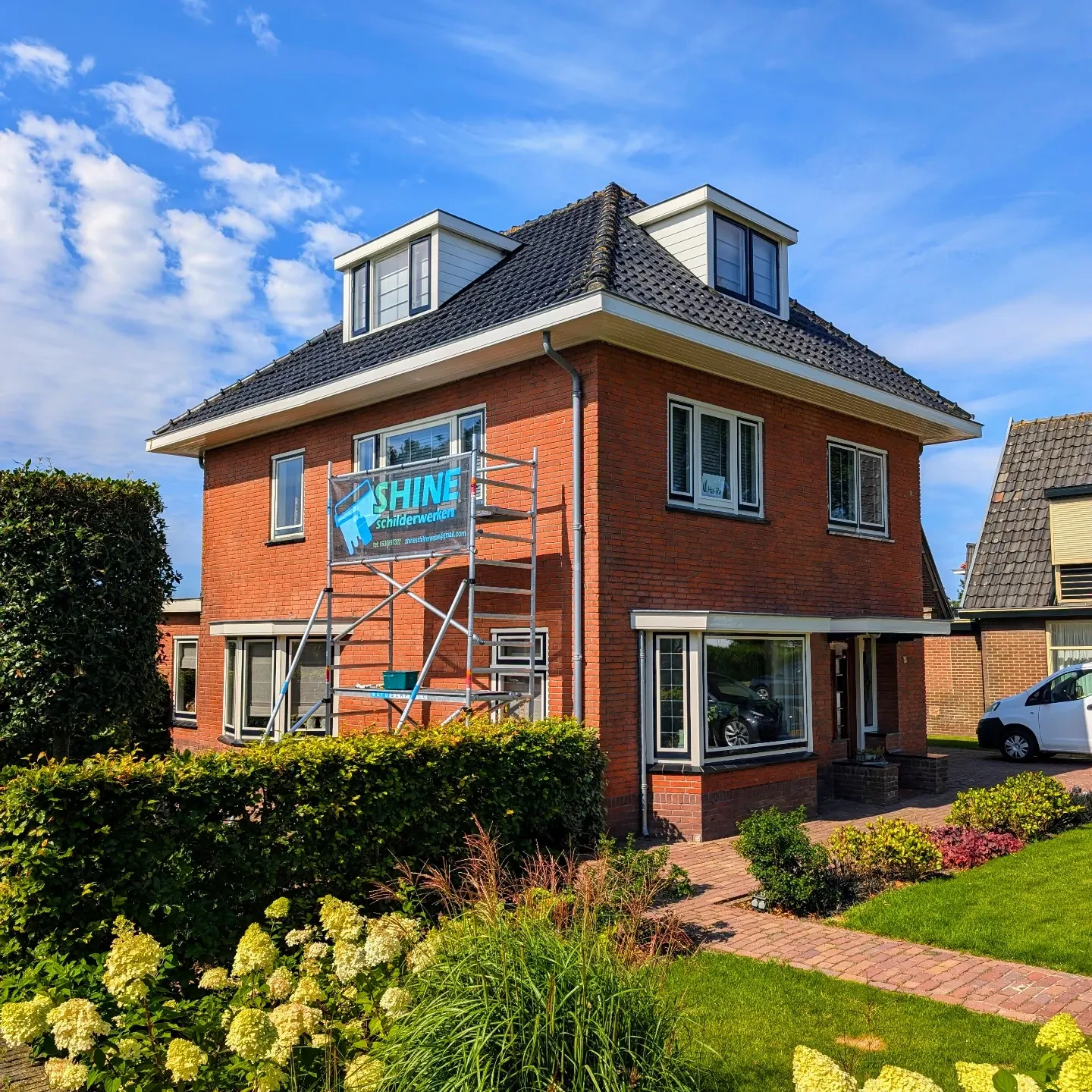 Vrijstaande woning in de steigers met het Shine schilderwerken spandoek