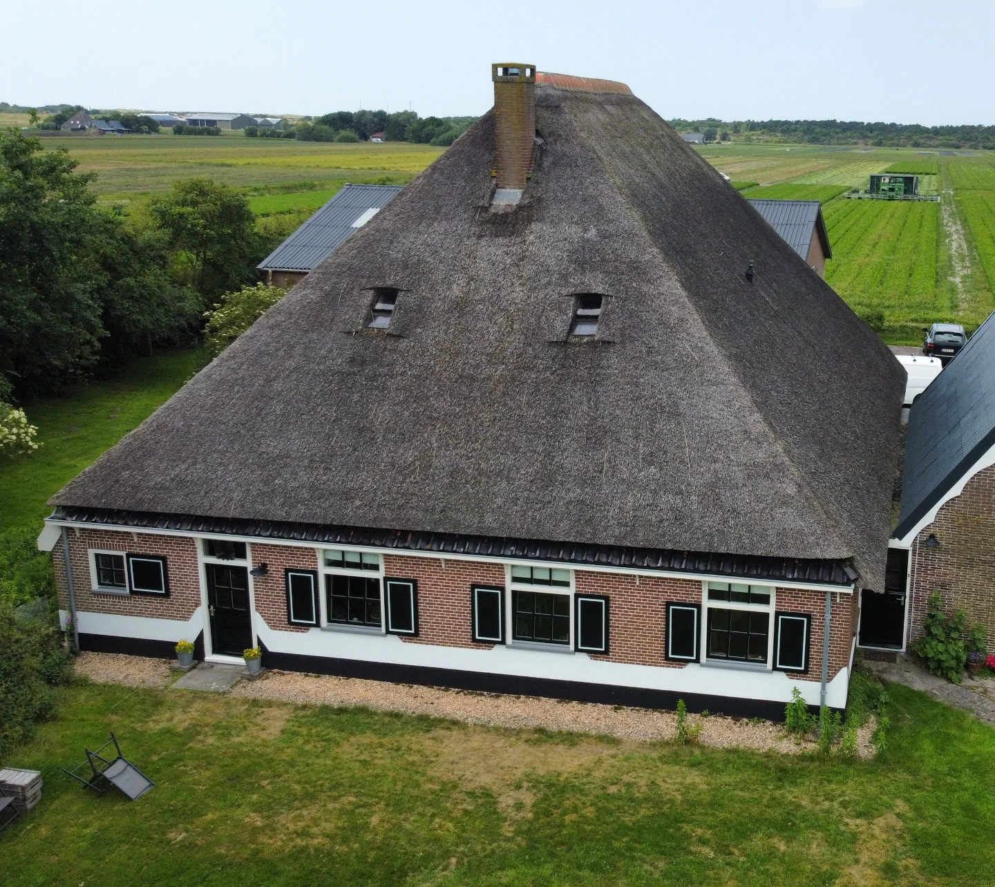 Dezelfde boerderij van dichtbij met vers geschilderde witte en zwarte kozijnen